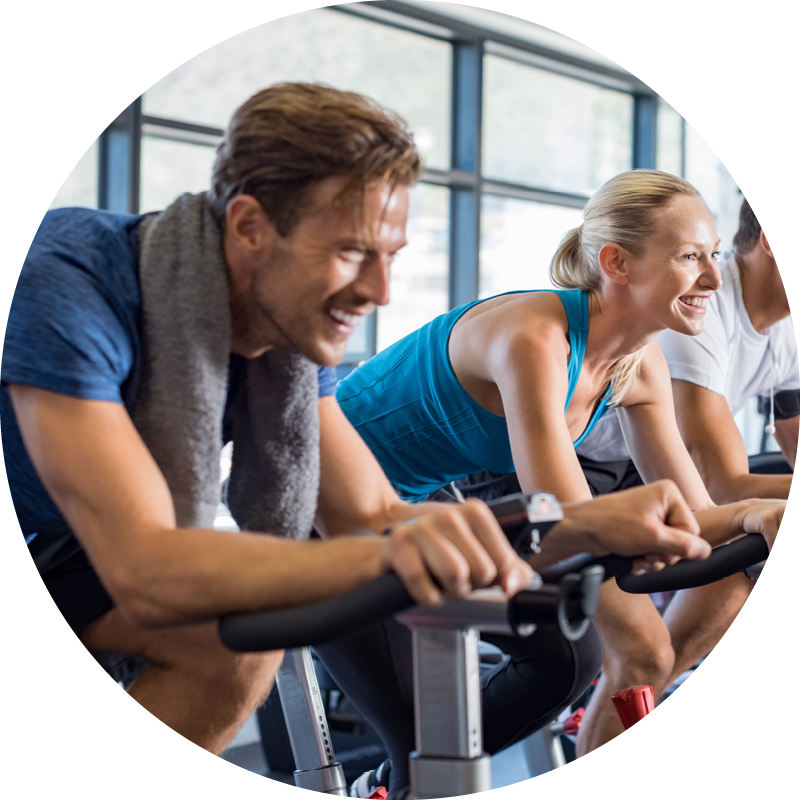 A happy middle-aged man in a spinning class